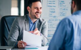 A recruiter speaks with a candidate in his office about a job opportunity - Job Search Journey