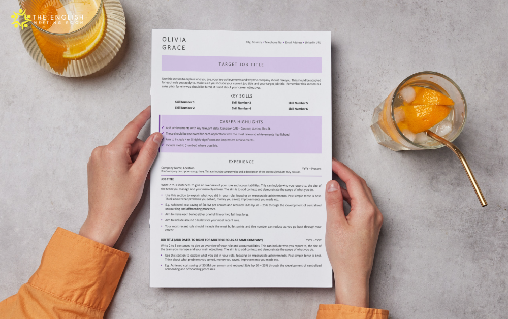 This image shows a resume template. The template is a purple design and its sitting on a grey table.